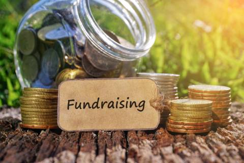 Coins in a jar with the word fundraising.